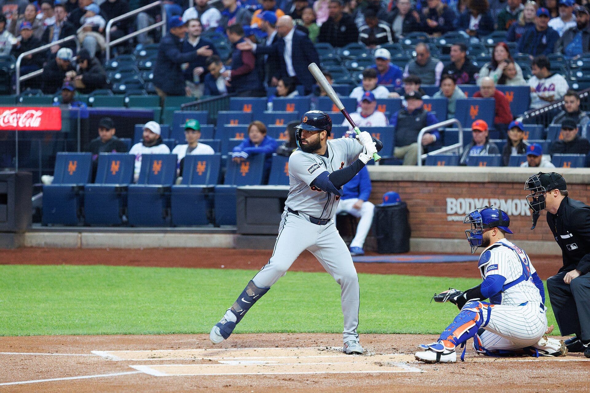 Detroit Tigers outfielder Riley Greene in a gray road uniform, set in his left-handed batting stance at the plate