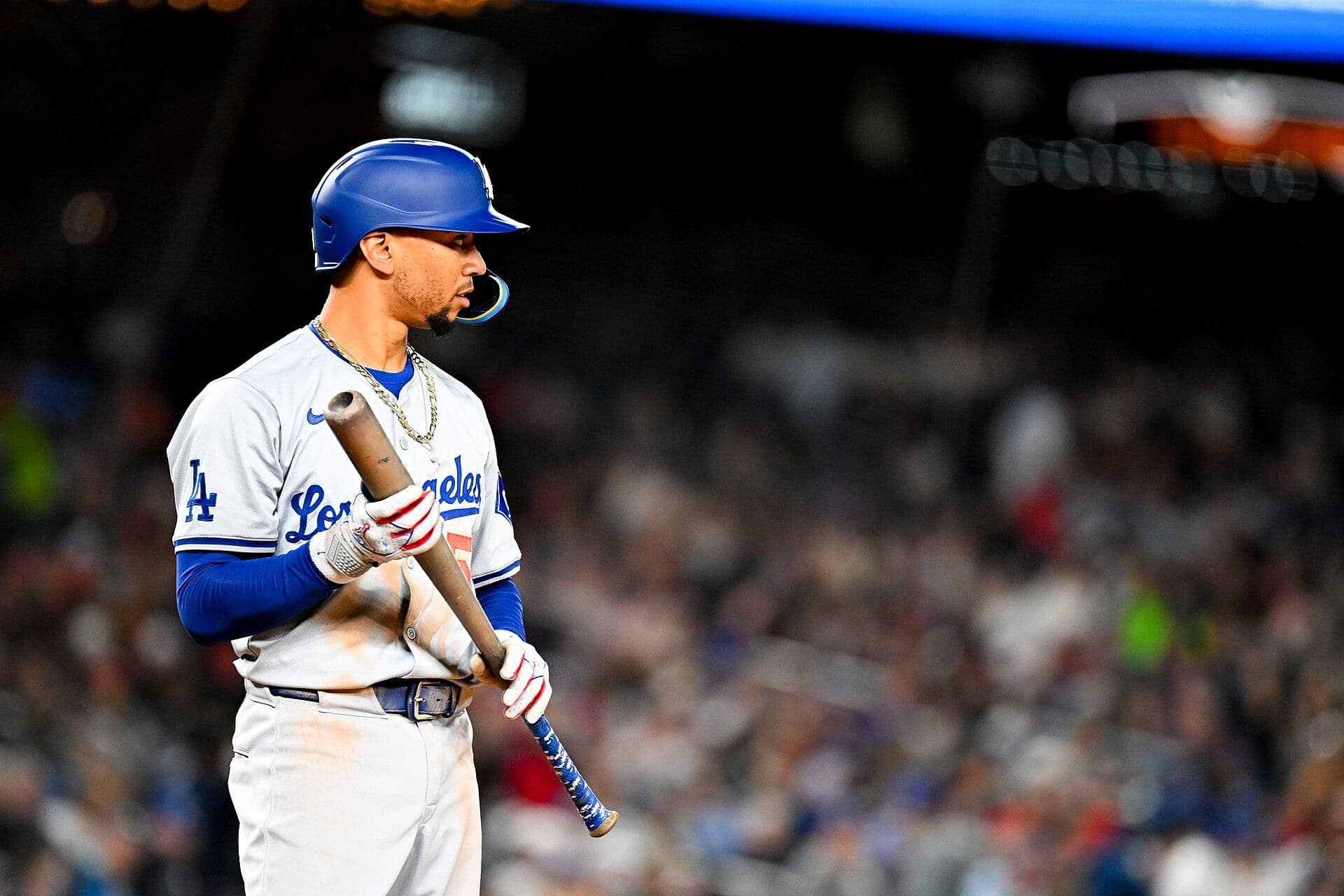 Los Angeles Dodgers star Mookie Betts stands at the plate holding his bat in a gray road uniform.