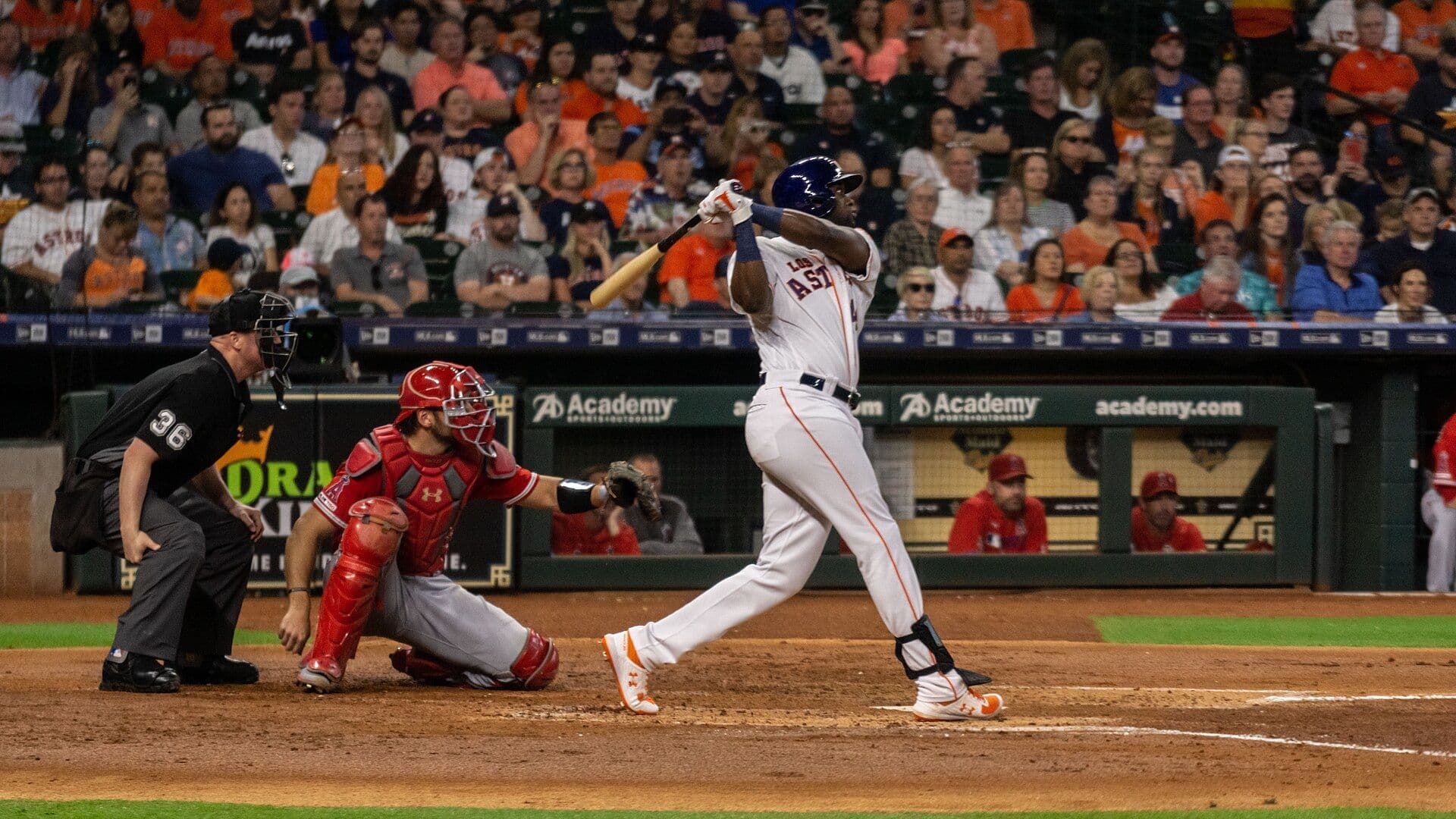 Houston Astros slugger Yordan Alvarez follows through on a swing in a cream home uniform.