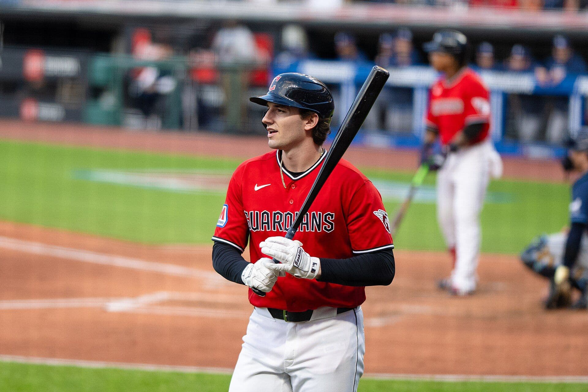 Chase DeLauter of the Cleveland Guardians stands at the plate in a red Guardians jersey and navy batting helmet, holding his bat upright before an at-bat.