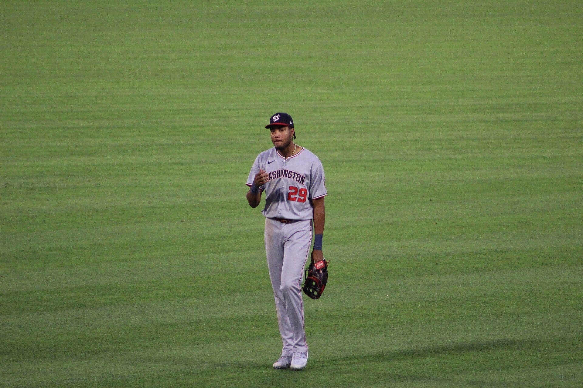 Washington Nationals outfielder James Wood standing in the outfield in his gray road uniform, glove in hand.